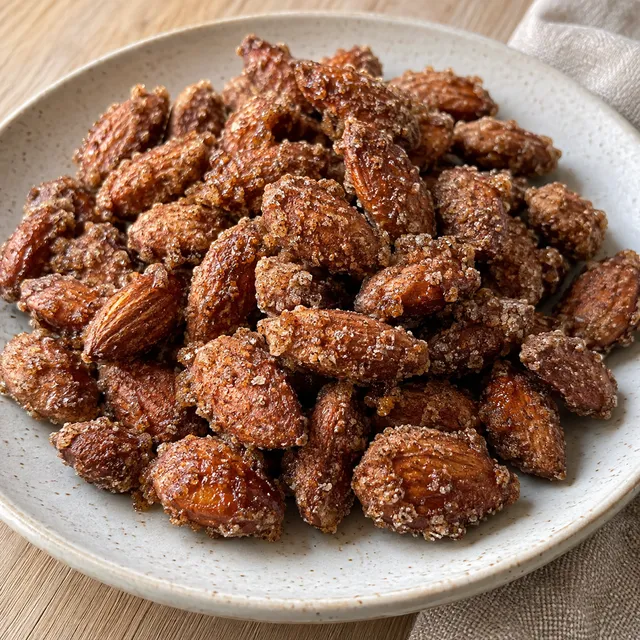 Brända mandlar med grynigt kanelsocker och små gyllenbruna fläckar på ett ljust fat