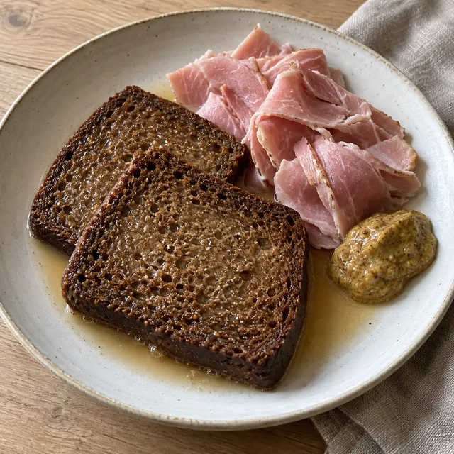 Doppat vörtbröd med kokt julskinka och senap på en ljus tallrik