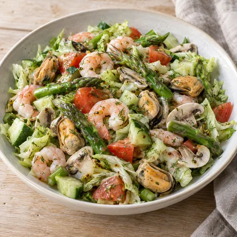 Västkustsallad med räkor, musslor, grön sparris och dilldressing på ljus tallrik